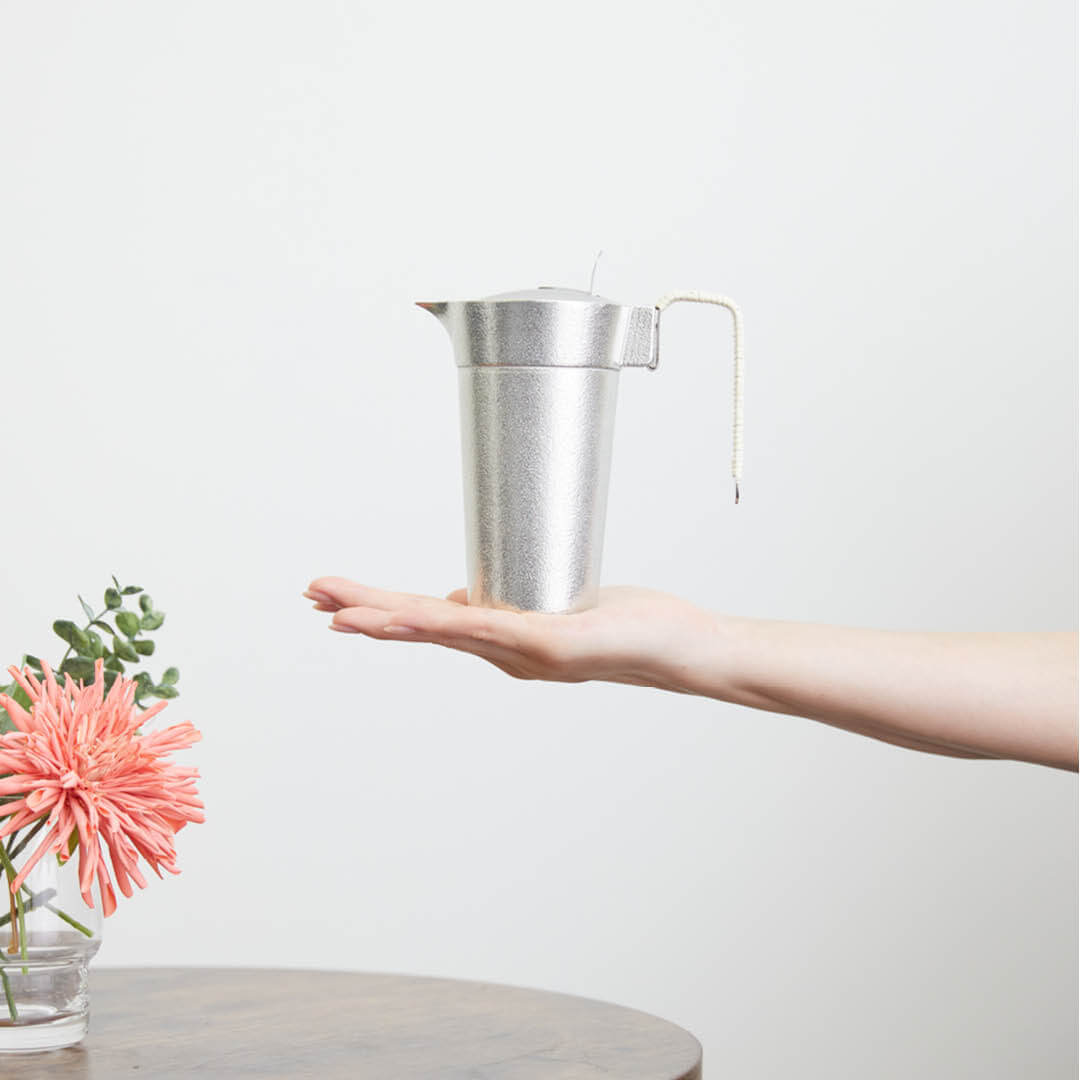 “Nousaku” Tin Chirori Sake Warmer With Lid, on a hand