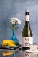 Dassai “45” Nigori Junmai Daiginjo, with a clear glass cup, served with gouda cheese and olives