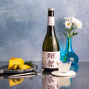 Dassai “45” Nigori Junmai Daiginjo, with a clear glass cup, served with gouda cheese and olives