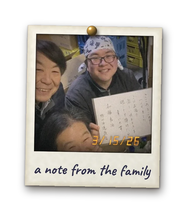 Polaroid: the Gonda family with a handwritten note, boxes ready to ship. Date stamp 3/15/26. Handwritten: a note from the family